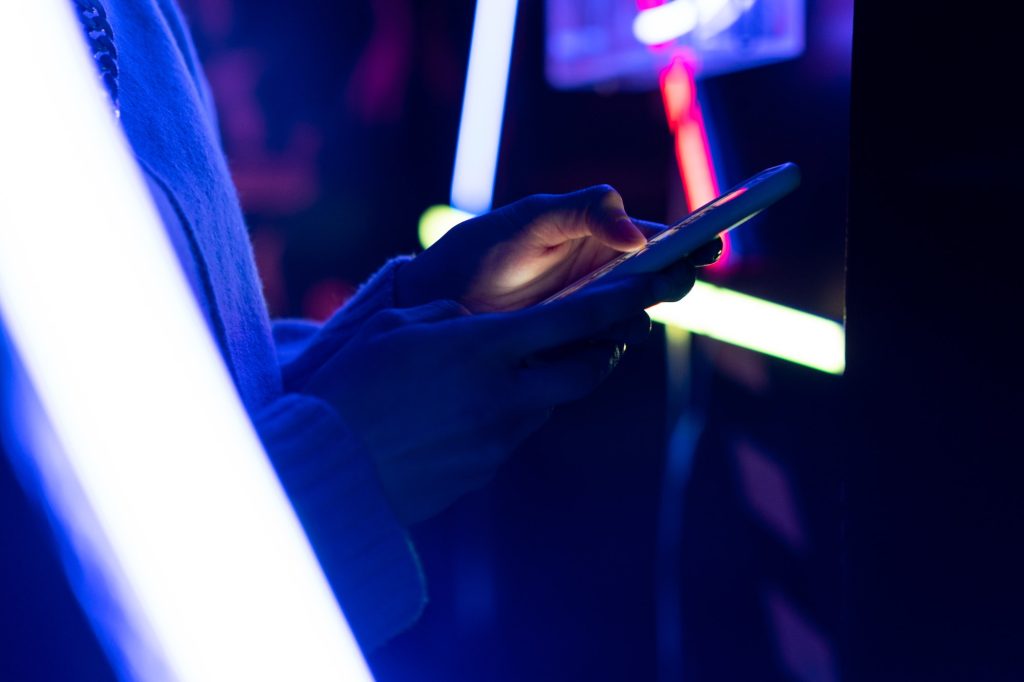 Female using mobile device at neon lights